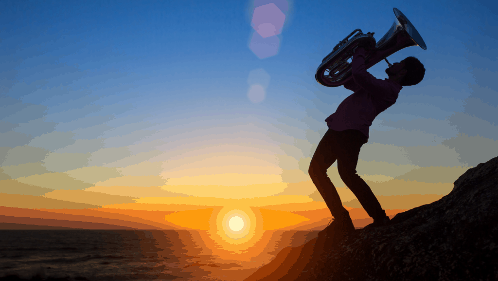 A man plays tuba under sunset