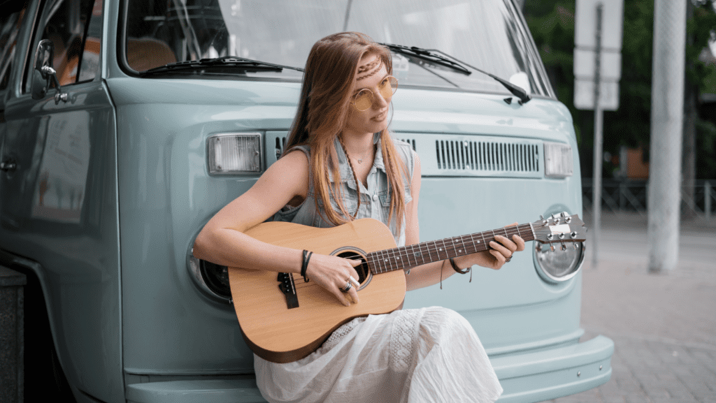 Girl playing 1/2 size guitar while traveling